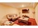 Inviting basement living room area featuring plush seating, a flat-screen TV, and cozy lighting at 16650 E 107Th Ct, Commerce City, CO 80022