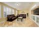 Cozy living room with leather seating, plantation shutters, and marble floors at 16650 E 107Th Ct, Commerce City, CO 80022
