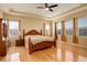 Spacious primary bedroom with wooden floor, ceiling fan, many windows and tray ceiling at 16650 E 107Th Ct, Commerce City, CO 80022