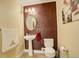 Stylish powder room with a pedestal sink, decorative mirror, and unique accent wall at 16650 E 107Th Ct, Commerce City, CO 80022