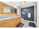 Stylish bathroom with double sinks, wood cabinets, and a tiled walk-in shower at 1890 Wynkoop St # 806, Denver, CO 80202