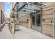 Building entrance featuring a modern design with brick accents, metal awning, and well-maintained landscaping at 1890 Wynkoop St # 806, Denver, CO 80202