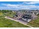 A sprawling backyard featuring an outdoor kitchen, seating, pergola, manicured lawn, and lush landscaping at 20503 E 50Th Pl, Denver, CO 80249