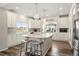 Spacious kitchen with a large island, white cabinets, pendant lights, and wood flooring at 20503 E 50Th Pl, Denver, CO 80249