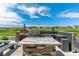 Outdoor kitchen complete with pizza oven and grill, perfect for entertaining with a granite countertop and bar seating at 20503 E 50Th Pl, Denver, CO 80249