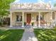 Inviting home showcasing a covered front porch with pillars, a swing, and a well-maintained lawn at 3929 Shoshone St, Denver, CO 80211