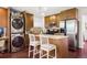 Modern kitchen with stainless steel appliances, breakfast bar, and unique washer-dryer stack at 3929 Shoshone St, Denver, CO 80211