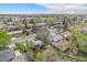 Lovely aerial view showcasing the neighborhood homes nestled amongst mature trees with the city skyline in the distance at 8209 Benton Way, Arvada, CO 80003