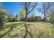 Spacious backyard with a deck, lush green lawn, and mature trees, perfect for outdoor activities at 8209 Benton Way, Arvada, CO 80003