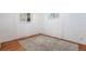 Bright bedroom featuring hardwood floors, neutral walls, and two windows for ample natural light at 8209 Benton Way, Arvada, CO 80003