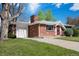 Well-maintained brick home with attached garage, showcasing its neatly landscaped front yard and curb appeal at 8209 Benton Way, Arvada, CO 80003