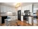Updated kitchen with white cabinets, stainless steel appliances, and a stylish dining table at 8209 Benton Way, Arvada, CO 80003