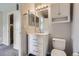 This bathroom features a vanity sink, a mirror and cabinet, and a toilet at 164 Bristlecone St, Brighton, CO 80601