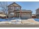 Two-story house with stone accents and attached garage, snow-covered front yard at 164 Bristlecone St, Brighton, CO 80601