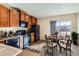 Eat-in kitchen features wood cabinets, black appliances, and a sliding glass door leading to a deck at 164 Bristlecone St, Brighton, CO 80601