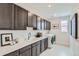 Well-equipped laundry room with ample cabinet space, sink, and modern washer and dryer at 12762 Bend Ct, Firestone, CO 80504