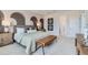 Cozy main bedroom features neutral tones, patterned accent wall, a seating bench, and a bright ensuite bathroom at 12762 Bend Ct, Firestone, CO 80504