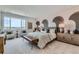 Serene main bedroom features neutral tones, patterned accent wall, cozy seating, and ample natural light at 12762 Bend Ct, Firestone, CO 80504