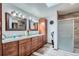 Bathroom featuring double vanity, wood cabinets and modern glass shower at 19 Carla Way, Broomfield, CO 80020