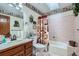 Cozy bathroom with pink tiled bathtub and decorative wallpaper border at 19 Carla Way, Broomfield, CO 80020