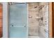 Close up of modern tiled shower with glass door and chrome fixtures at 19 Carla Way, Broomfield, CO 80020