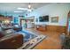 Open-concept living room with a fireplace, TV, and a view into the kitchen at 19 Carla Way, Broomfield, CO 80020