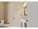 Cozy half bathroom showcasing a pedestal sink, decorative mirror and towel holder at 708 S Carlton St, Castle Rock, CO 80104