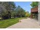 Large backyard featuring mature trees and a concrete patio and a fenced in area at 9117 Buck Hill Dr, Highlands Ranch, CO 80126