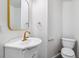 Powder room featuring a white vanity, brushed gold faucet, a modern mirror, and a toilet at 9117 Buck Hill Dr, Highlands Ranch, CO 80126