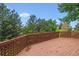 A spacious deck with wood flooring and railing is surrounded by lush greenery and trees, perfect for outdoor relaxation at 9117 Buck Hill Dr, Highlands Ranch, CO 80126