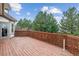 Outdoor wooden deck and lattice with tall pine trees in the background create an inviting place to relax at 9117 Buck Hill Dr, Highlands Ranch, CO 80126