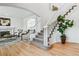 Open entryway with hardwood floors, elegant staircase, and view into the living room at 9117 Buck Hill Dr, Highlands Ranch, CO 80126