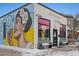 Charming coffee shop exterior featuring colorful mural art, large windows, and sidewalk seating at 3005 California St, Denver, CO 80205