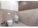 Modern bathroom with a unique design featuring a toilet and urinal, complemented by textured walls and flooring at 2206 Alpine Dr, Boulder, CO 80304