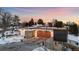 Modern home featuring a unique roofline, concrete accents, and a spacious driveway, set against a vibrant sunset sky at 2206 Alpine Dr, Boulder, CO 80304