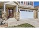 Welcoming entrance featuring a brick facade, a three-car garage, and a well-manicured lawn at 5131 Netherland St, Denver, CO 80249