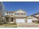 Charming two-story home featuring brick accents, a three-car garage, and a well-maintained front lawn at 5131 Netherland St, Denver, CO 80249