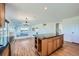 Open concept kitchen with island, wood cabinets, hardwood floors, and lots of natural light at 5131 Netherland St, Denver, CO 80249