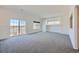 Bright living room with large sliding glass door, large window, and neutral carpet at 5131 Netherland St, Denver, CO 80249
