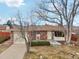 Brick ranch home with attached garage and mature trees at 4611 S Queen St, Littleton, CO 80127