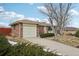 Brick ranch home with attached garage and landscaping at 4611 S Queen St, Littleton, CO 80127