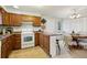 Bright kitchen with wood cabinets, white appliances, and an island at 4611 S Queen St, Littleton, CO 80127