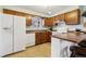 White appliances and wood cabinets in this galley kitchen at 4611 S Queen St, Littleton, CO 80127