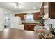 Kitchen with wood cabinets, white appliances, and a breakfast bar at 4611 S Queen St, Littleton, CO 80127