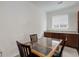 Dining area with a glass-topped table, wood chairs, neutral paint, and window views at 9643 Birch Ln, Thornton, CO 80229