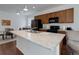 Kitchen featuring granite counters, black appliances, a breakfast bar, and an adjacent dining area at 9643 Birch Ln, Thornton, CO 80229