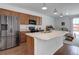 Open kitchen design boasting a center island, stainless steel refrigerator, and black appliances at 9643 Birch Ln, Thornton, CO 80229