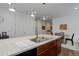 Kitchen island with a double sink, stainless steel appliances, and adjacent dining area at 9643 Birch Ln, Thornton, CO 80229