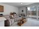 Comfortable living room features a large sectional couch, sliding glass door access to backyard at 9643 Birch Ln, Thornton, CO 80229