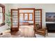 Sunlit living room with hardwood floors and decorative wood framed opening into adjacent room at 1018 Fillmore St, Denver, CO 80206